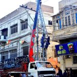HESCO workers busy in installing new electric pole with help of crane at outside court road