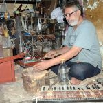 An artisan repairs a harmonium at his workplace