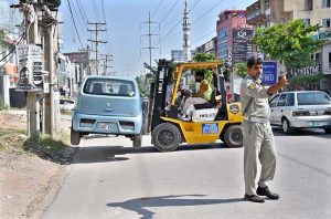 A wrongly parked car being lifted with the help of a lifter on PWD Road; a special operation against illegal parking is currently underway