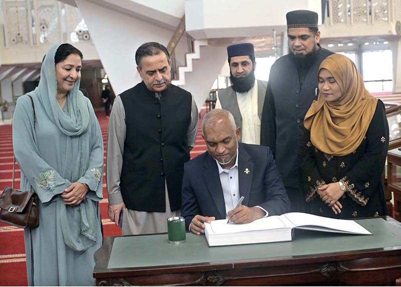 President of the Republic of Maldives Dr. Mohamed Muizzu writing his remarks in the visitors' book during his visit to the Faisal Mosque