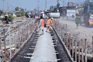 Workers install drainage pipes along Ring Road as part of ongoing development work to improve the city’s drainage system