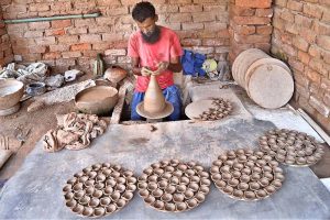 A craftsman preparing oil lamp in connection with upcoming Hindu festival Dewali at his work place near Jamshoro road