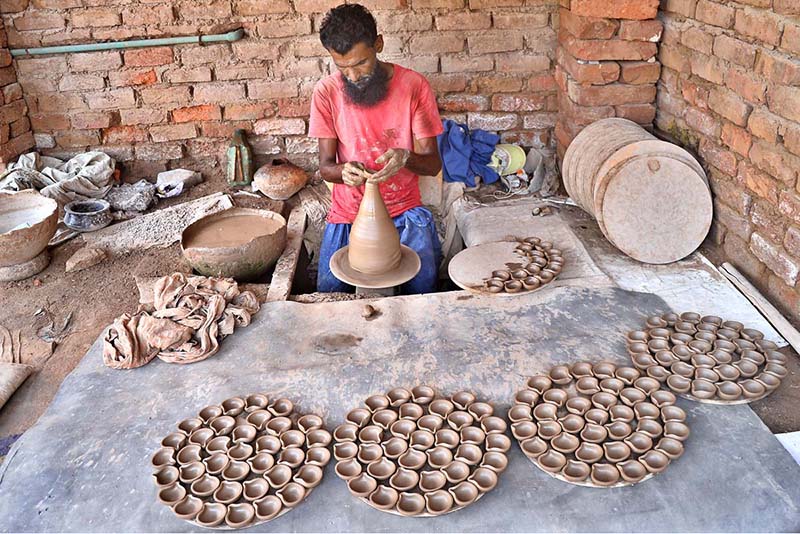 A craftsman preparing oil lamp in connection with upcoming Hindu festival Dewali at his work place near Jamshoro road