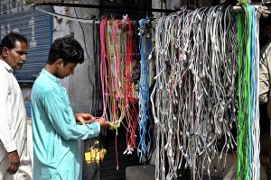 A young man is selecting mobile phone cables on Hall Road