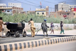 Workers engage in road construction as part of ongoing development activities on Autobahn Road
