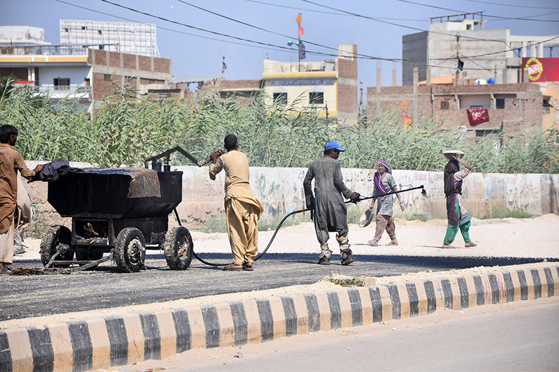 Workers engage in road construction as part of ongoing development activities on Autobahn Road
