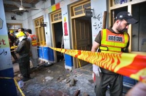 Rescue 1122 worker busy in rescue operation of the roof of a school building caved in, killing 33 children and a female teacher here at Dir Colony.
