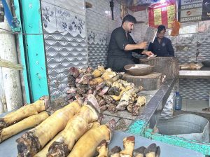 A vendor cutting paye (cow trotters) for customers at Bani Market.
