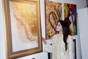 A female visitor views paintings and calligraphy displayed at an exhibition organized in collaboration with the Knowledge of Art Academy and the Punjab Institute of Language, Art and Culture (PILAC) at Gaddafi Stadium.