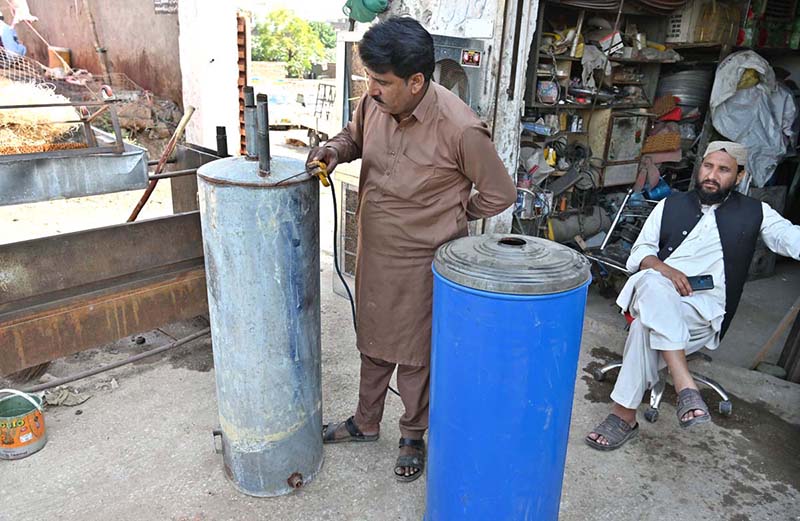 A worker is busy repairing a gas geyser at his workplace in the Federal Capital