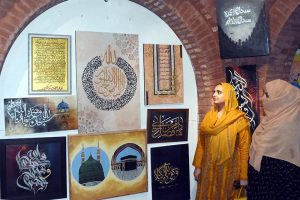 A female visitor views paintings and calligraphy displayed at an exhibition organized in collaboration with the Knowledge of Art Academy and the Punjab Institute of Language, Art and Culture (PILAC) at Gaddafi Stadium.