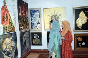 A female visitor views paintings and calligraphy displayed at an exhibition organized in collaboration with the Knowledge of Art Academy and the Punjab Institute of Language, Art and Culture (PILAC) at Gaddafi Stadium.