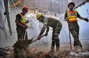 Rescue 1122 worker busy in rescue operation of the roof of a school building caved in, killing 33 children and a female teacher here at Dir Colony.