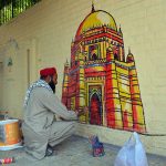 An artist paints a mural depicting the shrine of Hazrat Bahauddin Zakariya on a wall at the historic Mission Hospital in Cantt to enhance the beauty of the city