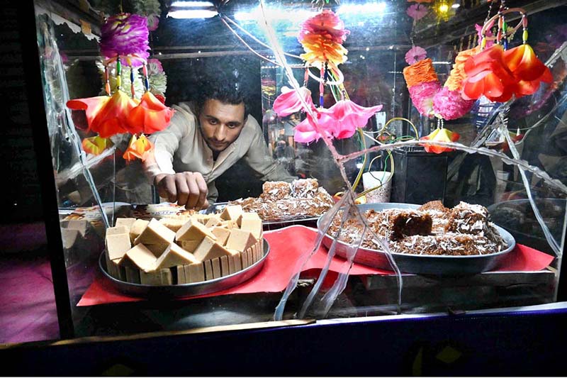 A street vendor is displaying sweets and traditional Sohan Halwa on a handcart to attract customers at road side setup in the City