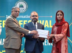Javed Iqbal Mirza, Director General Federal Education giving away books to students during 3rd International Seerat Festival, “International Seerat Conference”.