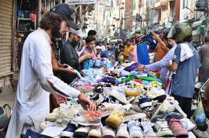 A woman carries cotton-filled quilts (razais) as the weather begins to turn cooler in the city