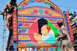 An artist is putting the finishing touches to a portrait of the martyred former PM Benazir Bhutto on the back of a truck in the Hala Naka area.