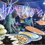 Vendors preparing and display the different kinds of traditional food items to the customer on the roadside colorful stalls during a Dada Hanjer Pir local mela festival at fair ground near Multan road