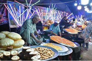 Vendors preparing and display the different kinds of traditional food items to the customer on the roadside colorful stalls during a Dada Hanjer Pir local mela festival at fair ground near Multan road