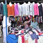 Women select and purchase used clothes at the I-9 weekly bazaar in the Federal Capital