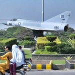 A Pakistan Air Force aircraft displayed along a road in Hayatabad as motorists pass by in the provincial capital
