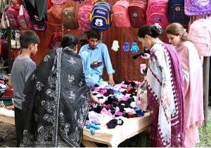 Women select and purchase used clothes at the I-9 weekly bazaar in the Federal Capital