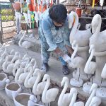 A vendor displaying animal statue after preparing to attract the customers at Eidgah road