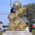Municipal employees install an ornamental structure to enhance the beauty of area near Hayatabad Toll Plaza