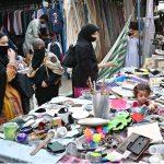 Women select and purchase used household items at the I-9 weekly bazaar in the Federal Capital