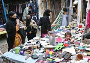 Women select and purchase used household items at the I-9 weekly bazaar in the Federal Capital