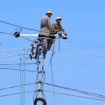 PESCO line workers carry out maintenance work on a power transmission pole along Ring Road