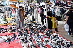 Women select and purchase used household items at the I-9 weekly bazaar in the Federal Capital