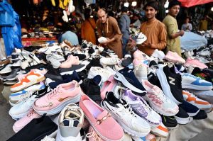 People browse and purchase second-hand shoes from vendors at Landa Bazaar in the provincial capital