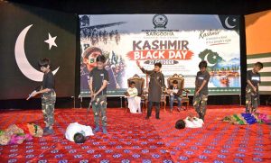 Children dressed in Kashmiri attire view photographs depicting alleged Indian atrocities against the Kashmiri people during a Kashmir Black Day event at the Arts Council.