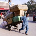 A labourer pushes a loaded cart in the Tower area of the city