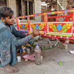 A worker paints a donkey cart at his workplace near Peer Sher Road