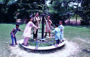 Children enjoying swings at a park in the city.
