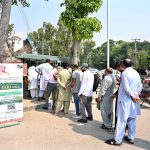 People are standing in queue for receiving petrol relief token at Club Road