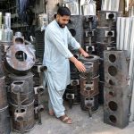 Man displaying traditional stoves as per increased demand in winter season at Surajganj Bazaar