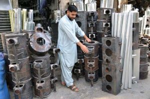 Man displaying traditional stoves as per increased demand in winter season at Surajganj Bazaar