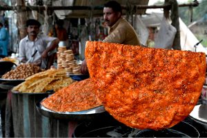 A vendor preparing the traditional food item Katlama (traditional food like pizza) to the customer on the roadside setup in the Provincial Capital.
