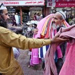 An elderly man is selling towels in Bohra Bazaar