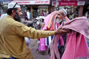 An elderly man is selling towels in Bohra Bazaar