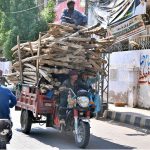 A tricycle loader on its way, loaded with shuttering material at GPO Road