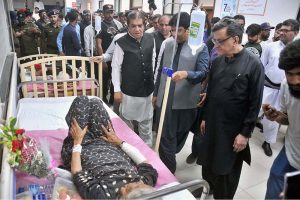 Federal Minister for Railways Muhammad Hanif Abbasi inquires about the health of an injured passenger during his visit to Nishtar Hospital following the derailment of the Rehman Baba Express near Sher Shah Railway Station