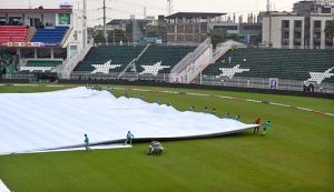 Women police officials shield themselves with umbrellas from the rain before the start of the third T20 cricket match between Pakistan and Sri Lanka at Rawalpindi Cricket Stadium
