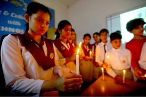 Students light candles during a vigil to pay tribute to the martyrs of the Dir school tragedy.