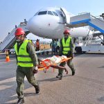 Fire and rescue personnel carry a simulated burn victim on a stretcher away from an Airbus A321 aircraft during a Full-Scale Emergency Exercise conducted by the Pakistan Airports Authority (PAA) at Multan International Airport to evaluate staff operational readiness and emergency evacuation procedures