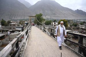 An elderly man walks across the historic suspension bridge in Konodass, Gilgit